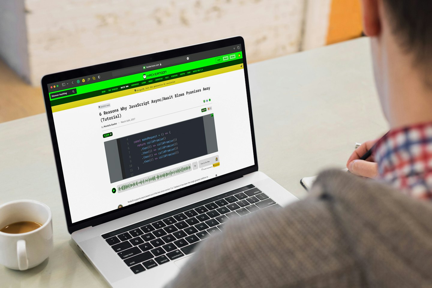 Osoba pracująca na laptopie z filiżanką kawy.